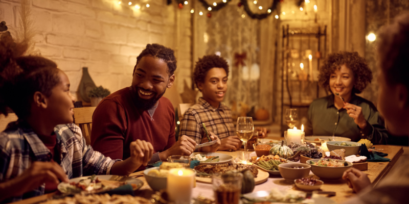 family eating around a Thanksgiving meal, holiday guests, pet parents, pet safety, Animal Emergency & Referral Center of Minnesota