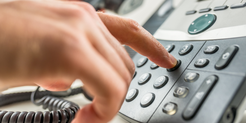 A hand dialing a phone number on a phone, toxicology hotline, Animal Emergency & Referral Center of Minnesota