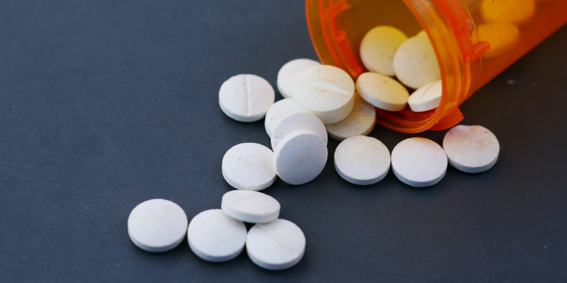 Medication bottle with pills spilling out.