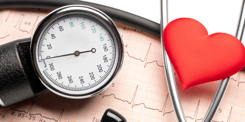 A blood pressure monitor, stethoscope, and heart-shaped figure over a printed ECF results report. 