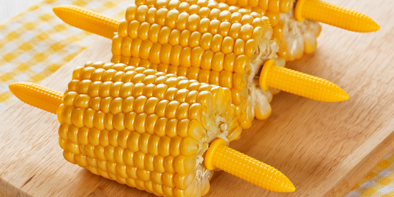 A row of corn cobs on a serving platter.