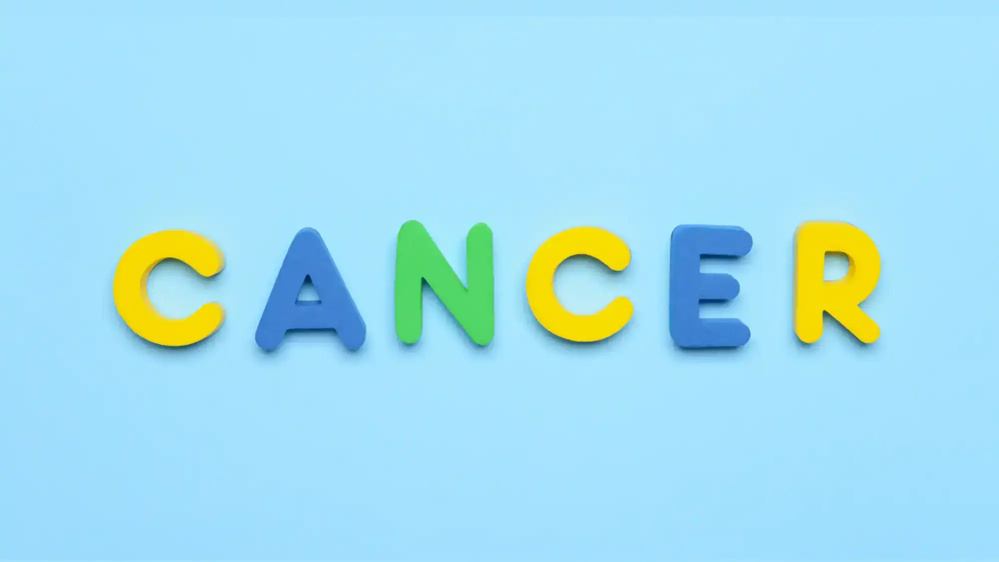 A blue background with magnetic letters that spells out "CANCER"