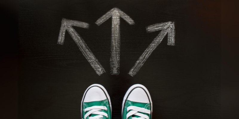 An image of green Converse shoes in front of three chalk arrows, all pointing in different directions.