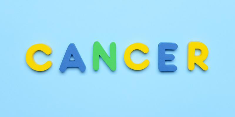 A blue background with magnetic letters that spells out "CANCER"
