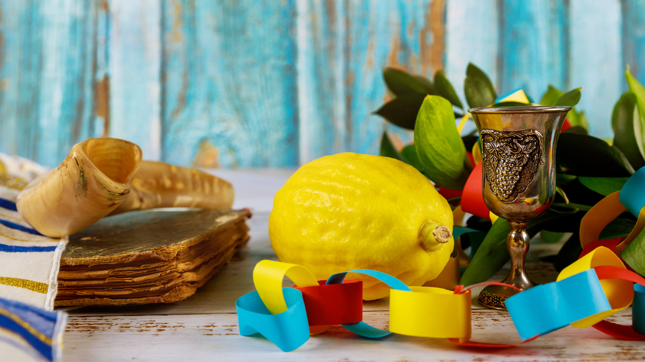 Sukkot table with paper chain decorations, lemons, food, and decorations.