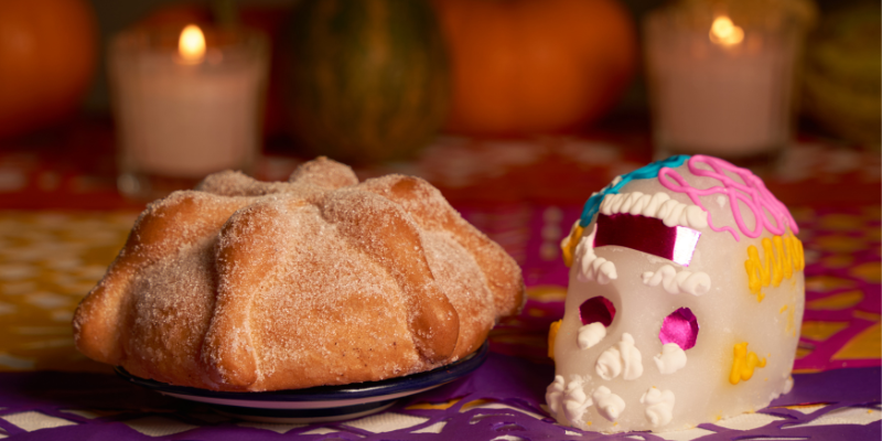 Pan de Muerto on a table with a sugar calavera.