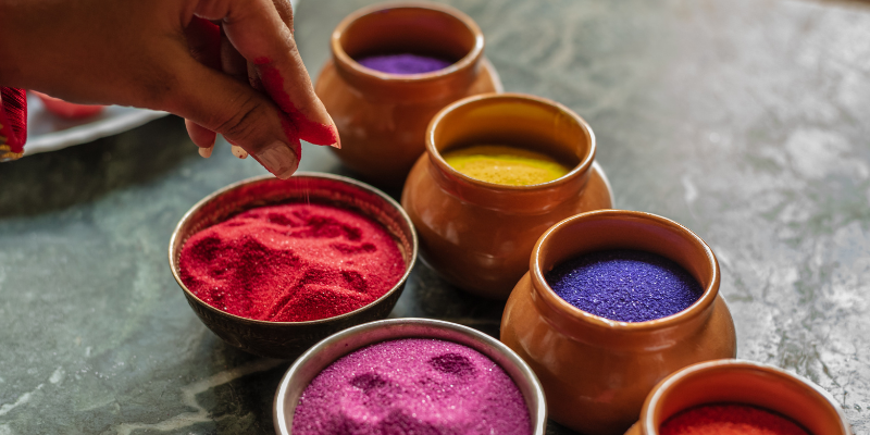 Several jars of different color sands for rangoli art. 
