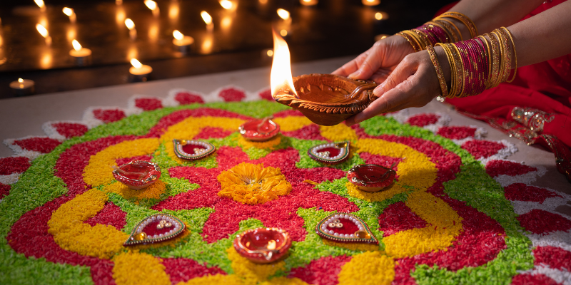 A colorful rangoli display with diyas.