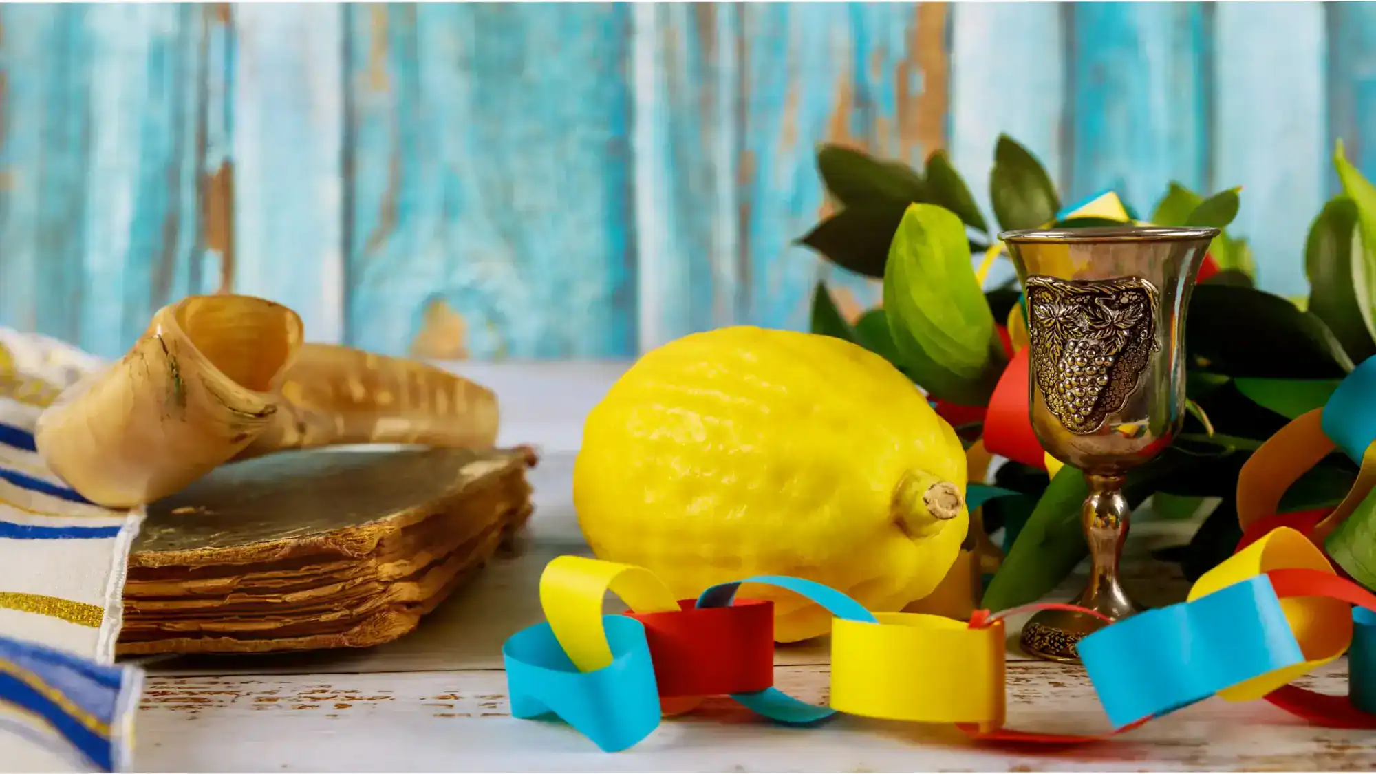 Sukkot table with paper chain decorations, lemons, food, and decorations.