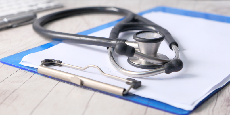 A stethoscope on top of a medical records chart.